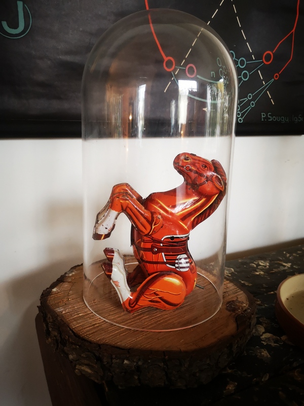 Tin toy under bell